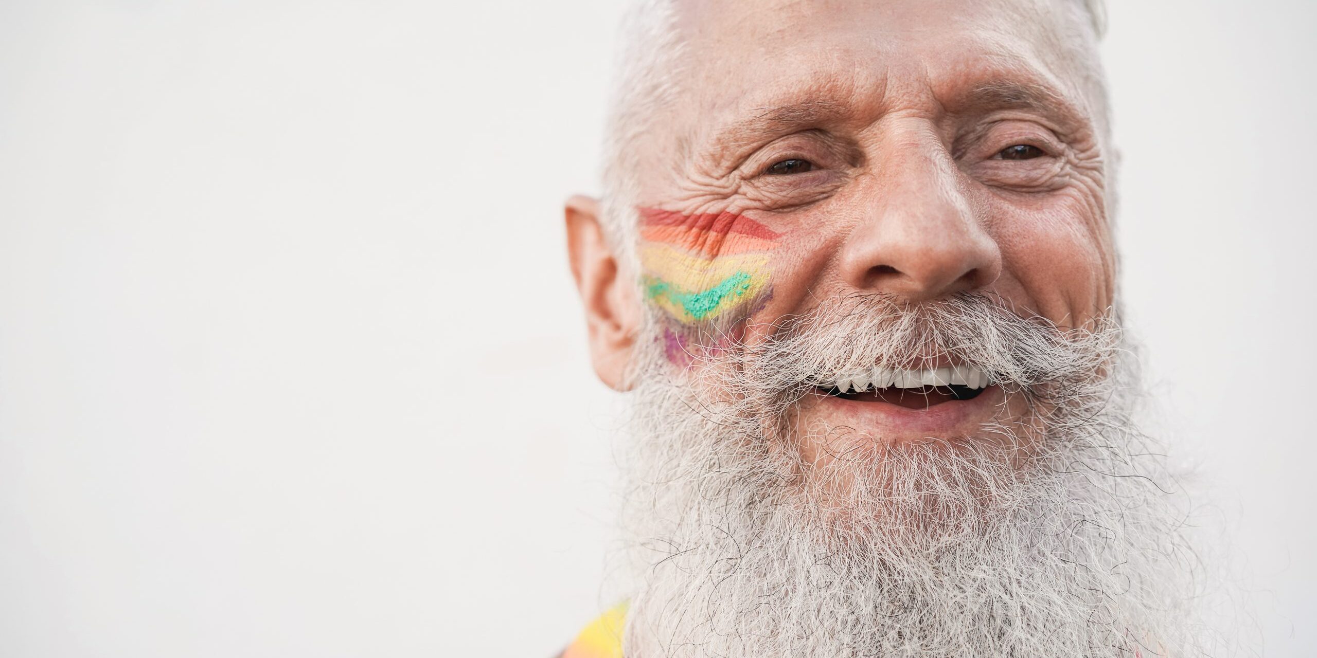 Senior gay man smiling during lgbt pride protest - Focus on face
